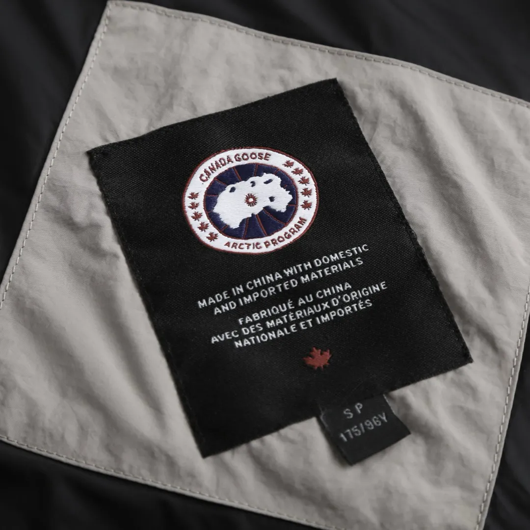 P1010 [Exclusive supply] Canada Goose Black Label Badge Hooded Down Jacket (Khaki) The high-quality filling is made of 90 national standard high-quality white duck down, selected high-loft velvet, weighing 240g, light and warm, with excellent temperature locking performance and good resilience. The fabric is woven with 400T high-count yarn. After special water-repellent treatment, the surface forms a lotus leaf effect - raindrops will slide down like beads, and snow particles will fall off when touched. The tear resistance reaches 200N (approximately 20kg load-bearing), the light gray matte texture breaks the stereotype of "outdoor clothing = hardcore", and the soft luster presents a high-end matte effect under urban neon lights, seamlessly switching scenes from ski resorts to CBD office buildings. The ribbon is woven with polyester as the base, and the brand letters are decorated on the ribbon through high-precision computer embroidery. The edges of the pattern are clear, the stitches are fine and even, and multiple layers of embroidery thread are stacked to enhance the three-dimensional effect. Precision thread reinforcement prevents linting and ensures the fluffy and resilient elasticity lasts as new. The embedded cuffs are three-dimensionally woven to form a "wavy" elastic structure, which forms natural folds when fitting the wrist, increasing the contact area with the skin, thus improving the windproof effect. At the same time, micro-velvet treatment is added to the inside of the cuffs, which feels like a second layer of skin and avoids friction on the skin from metal zippers or hard fabrics. Size:S-M-L-XL